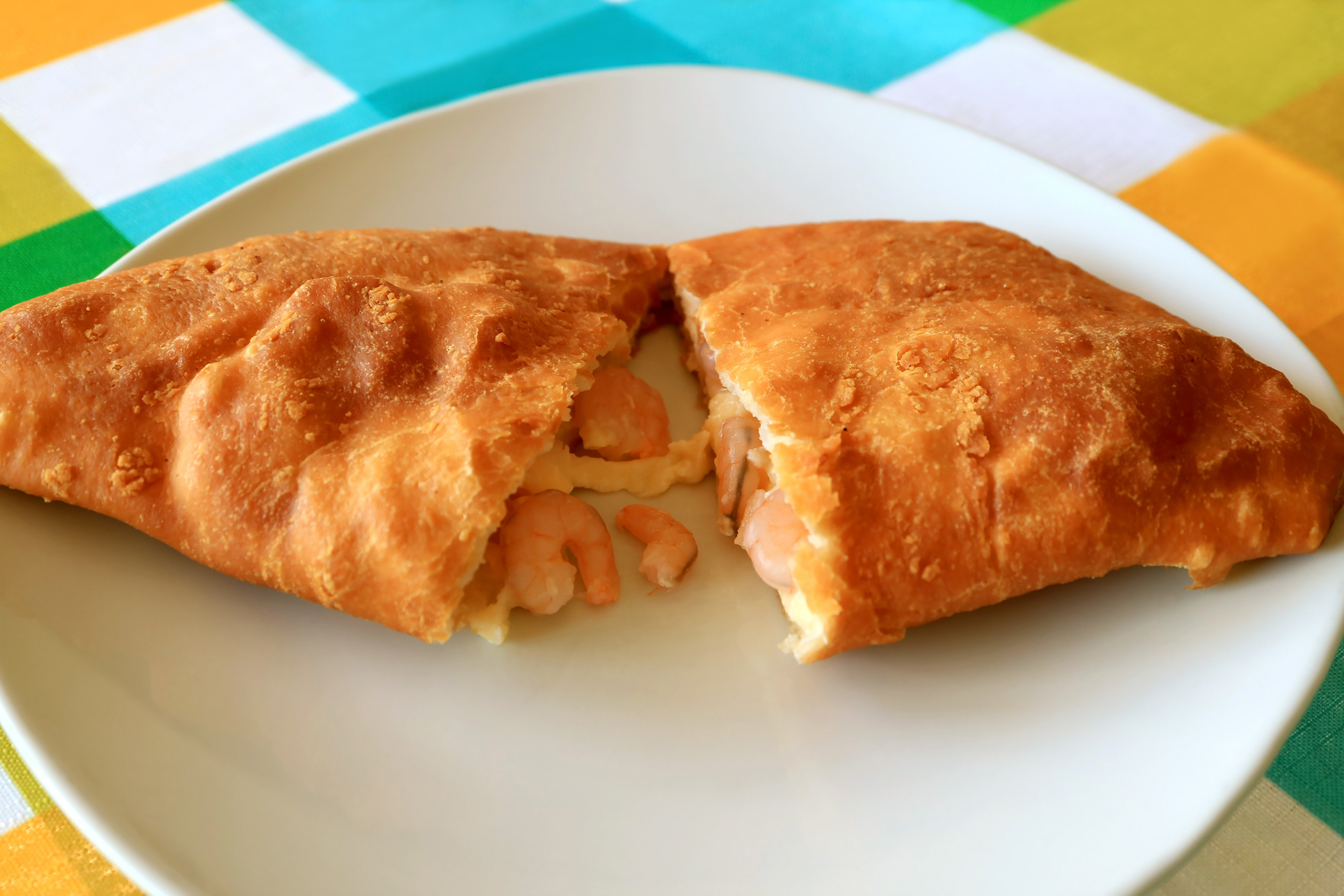 Plate of Empanada de Camarones or Shrimps and Cheese Filled Pastry Cut in Half